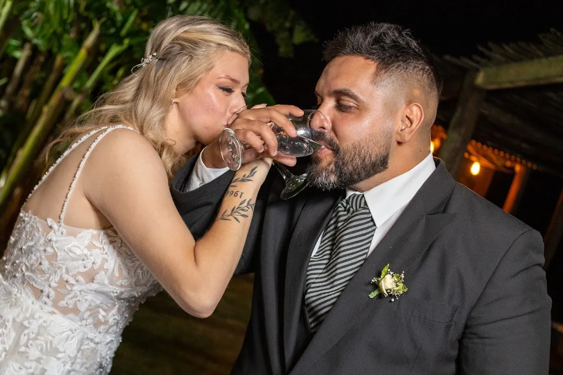 Brindis de los novios abrazados, entre plantas