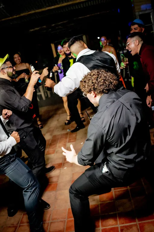 Invitados bailando en la pista con luces de neón
