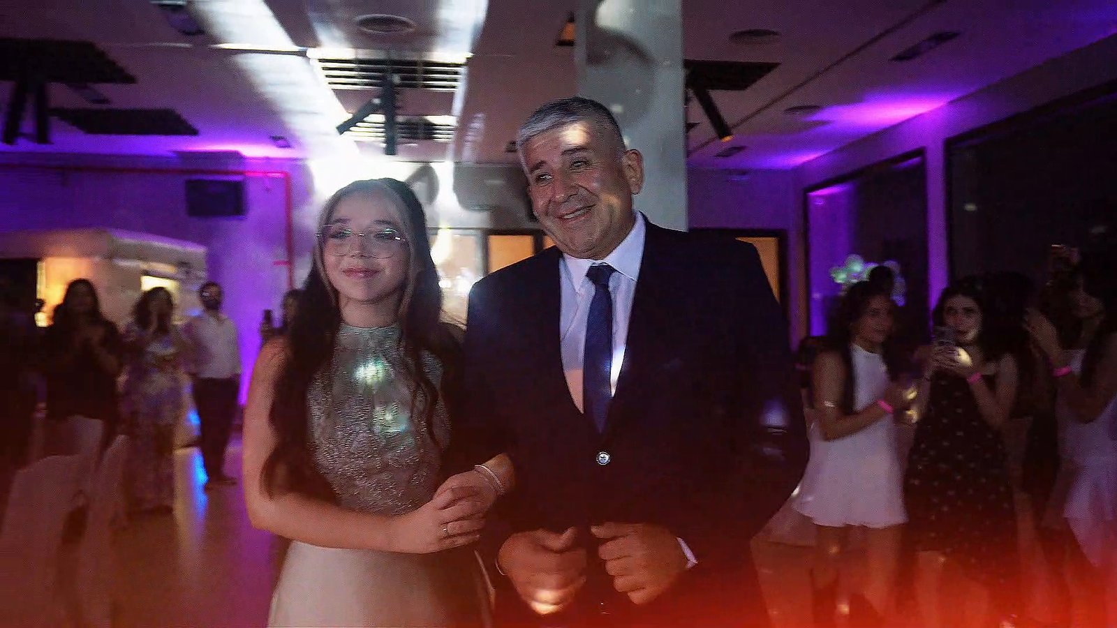 Una quinceañera entra a su fiesta del brazo de su padre