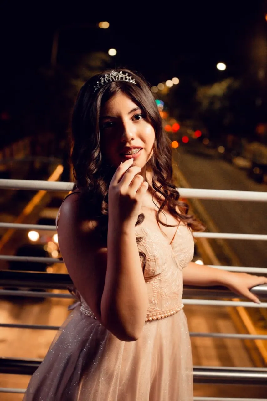 Retrato de noche en una pasarela, luces de la ciudad de fondo