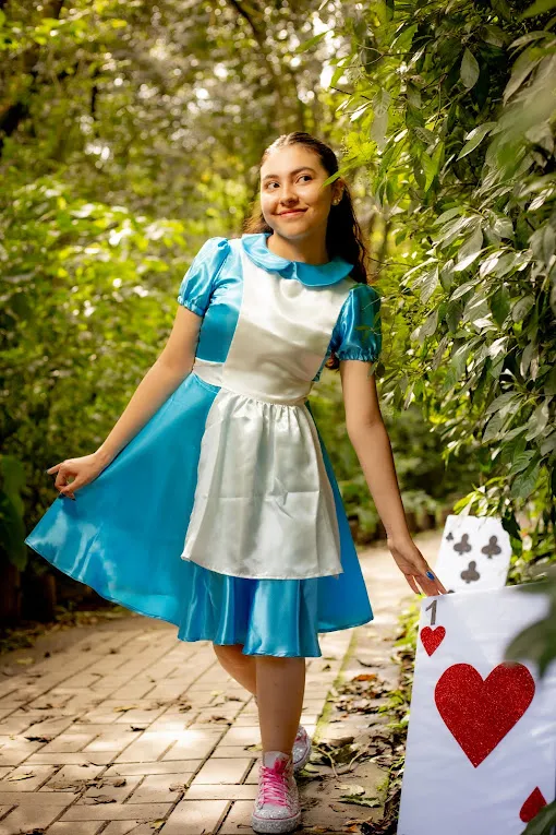 Book temático de Alicia, vestido girando junto a naipes gigantes