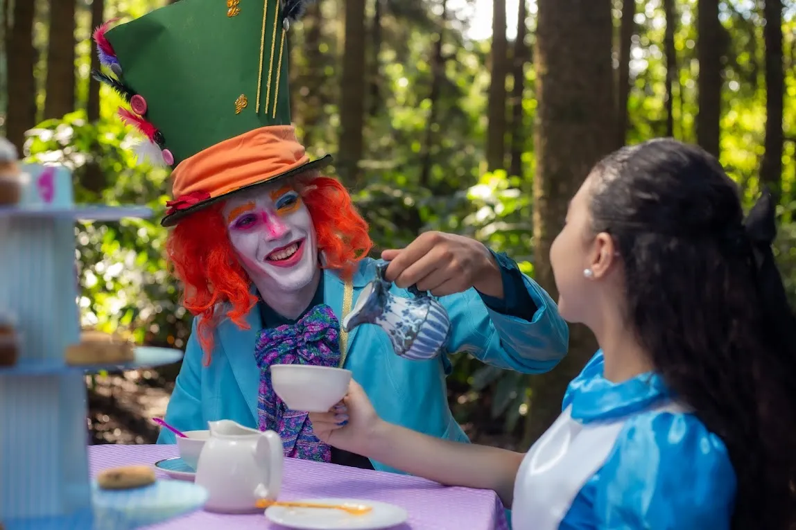 Personaje sirviendo té en la merienda temática